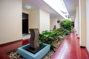 einen Flur mit einer Statue in der Mitte eines Gebäudes in der Unterkunft Super OYO 759 Hotel Dewi Sri in Timuran