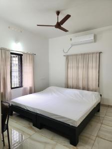 a bedroom with a bed and a ceiling fan at Olive Homestay 1bhk Diamond Ernakulam in Alwaye