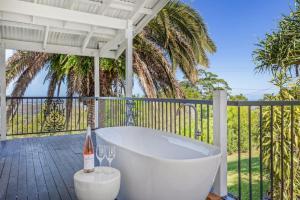 una vasca da bagno bianca su un patio con bicchieri da vino di The Breezy Maple - Hinterland and range views in Mapleton a Mapleton