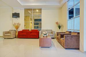 a living room with couches and chairs and a tv at Collection O 91414 Hotel Marina Beach in Makassar