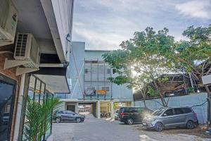 two cars parked in a parking lot next to a building at Collection O 91414 Hotel Marina Beach in Makassar