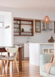 a kitchen and dining room with a table and a chair at Worrowing Jervis Bay in Huskisson