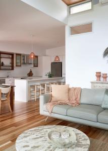 a living room with a couch and a kitchen at Worrowing Jervis Bay in Huskisson