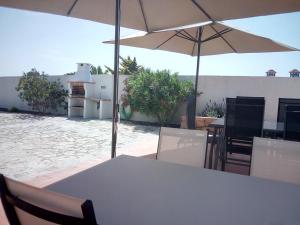 a table and chairs with an umbrella on a patio at Quinta Marvão in Ribamar