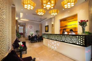 a lobby of a hotel with two people sitting at a counter at Hanoi Dragon Boutique Hotel in Hanoi