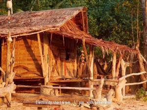 a log cabin with a thatched roof and a porch at Simple Life Bungalows in Ko Jum