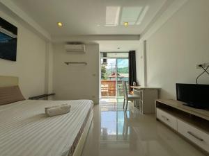 a bedroom with a bed and a television in it at Sleep inn Samui in Choeng Mon Beach