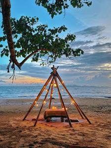 a picnic table with lights on the beach at Simple Life Bungalows in Ko Jum