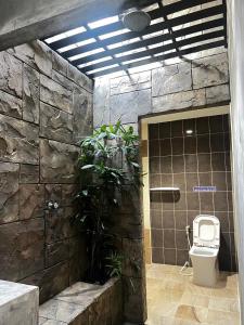 a bathroom with a toilet and a plant at เอนกายสบายรีสอร์ต in Ban Tha Nang Hom (1)