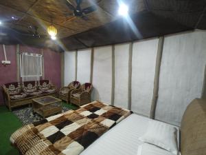 a bedroom with a bed and chairs in a room at AVA Resort, Kaziranga in Bokakhat