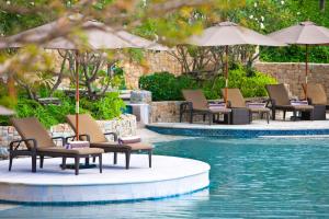 una fila de sillas y sombrillas junto a una piscina en The Westin Siray Bay Resort & Spa, Phuket en Phuket