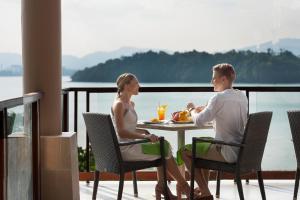 プーケットタウンにあるThe Westin Siray Bay Resort & Spa, Phuketのバルコニーのテーブルに座る男女