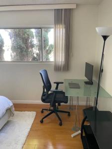 a bedroom with a desk with a computer and a chair at Charming and Bright Apartment in Los Angeles