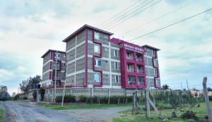 a red and white building on the side of a road at Maya Homes in Naivasha