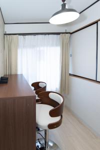a meeting room with four chairs and a desk at リノディア京橋 in Osaka