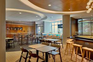 a restaurant with tables and chairs and a bar at SpringHill Suites by Marriott Atlanta Airport Gateway in Atlanta