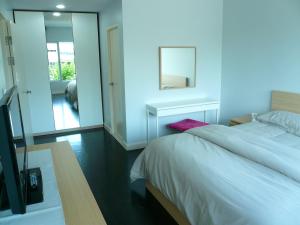 a bedroom with a white bed and a mirror at Baan San Dao Hua Hin in Hua Hin +22 photos