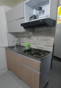 a kitchen with a stove and a sink at Apartamento en El Rodadero, Santa Marta in Santa Marta