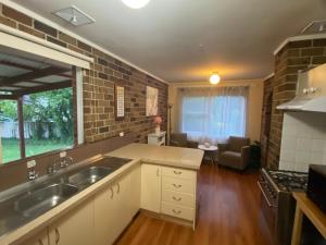 een keuken met een wastafel en een woonkamer bij Canberra Hospital Locum Welcome - Home in Harman