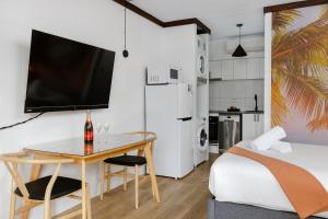 1 dormitorio con cama, mesa y TV en m hotel, en Sale