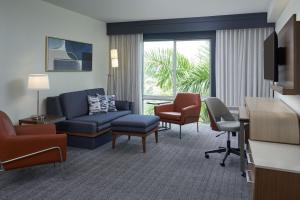 una sala de estar con sofá y sillas en una habitación de hotel en Courtyard by Marriott Fort Lauderdale Weston, en Weston