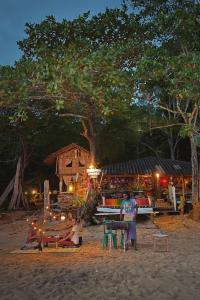 un grupo de personas sentadas en una playa por la noche en Simple Life Bungalows, en Ko Jum