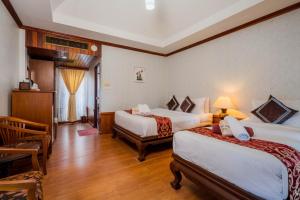 a hotel room with two beds and a table at Long Beach Lodge, Chaweng Beach, Koh Samui in Chaweng