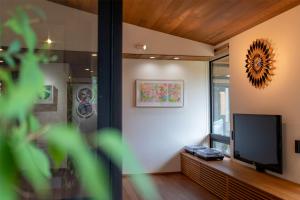 a living room with a flat screen tv on a wall at 隠れ家アートヴィラ Villa Revolla in Makinohara