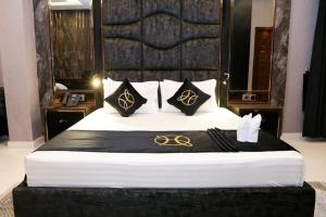 a bedroom with a large bed with black and gold pillows at Hotel Oasis by Signature in Islamabad +2 photos