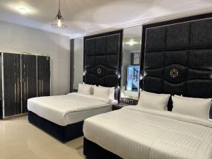 a hotel room with two beds with white sheets at Hotel Oasis by Signature in Islamabad