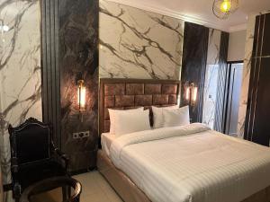 a bedroom with a bed and a marble wall at Hotel Oasis by Signature in Islamabad