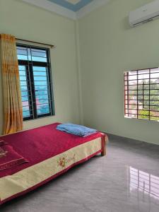 a bedroom with a bed in a room with two windows at HomeStay Ông Vinh 