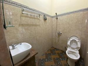 La salle de bains est pourvue de toilettes et d'un lavabo. dans l'établissement Homestay Syariah Desa Bahasa, à Magelang