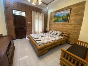 - une chambre avec un grand lit dans un mur en briques dans l'établissement Homestay Syariah Desa Bahasa, à Magelang