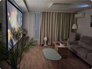 uma sala de estar com um sofá e uma televisão em Gaon guesthouse em Jeonju