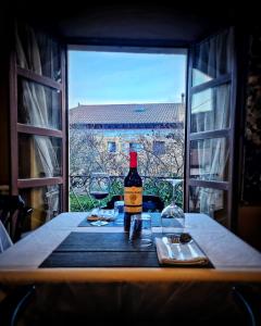 a bottle of wine sitting on a table with a window at La Villa in Canales de la Sierra