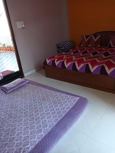 a bedroom with a bed and a purple rug at Atharva home stay in Ujjain
