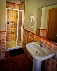 y baño con lavabo y ducha. en La Villa en Canales de la Sierra