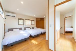 a bedroom with three beds and a mirror at Villa Revo Shizuoka Japan in Makinohara