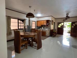 eine Küche und ein Esszimmer mit einem Tisch und Stühlen in der Unterkunft Khaolak 2K Pool Villa in Khao Lak