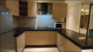 a kitchen with a black counter top and a microwave at 1.5BR Service apartment in BKC by Florastays in Mumbai