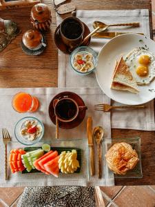 una mesa de madera cubierta con platos de comida en la parte superior en MATHIS Retreat Ubud, en Ubud