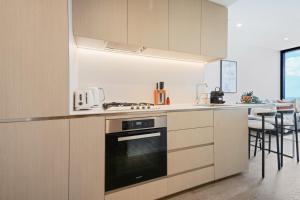 墨爾本的住宿－Prestige Living in Southbank，厨房配有白色橱柜和炉灶烤箱。