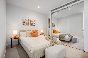 墨爾本的住宿－Prestige Living in Southbank，白色卧室配有床和椅子