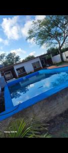 a large blue swimming pool in front of a building at Complejo francesca in Paso de la Patria