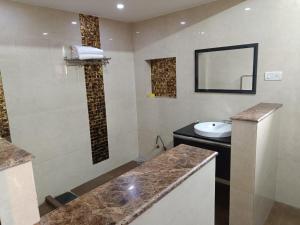 GK Residency Kailash Colony في نيودلهي: حمام مع حوض ومرآة