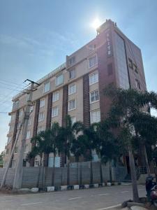 a large building with palm trees in front of it at Hotel Elite By Signature Group in Hyderabad