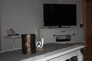 a living room with a tv and a trash can at Eifelhäusje Schäfer in Retterath