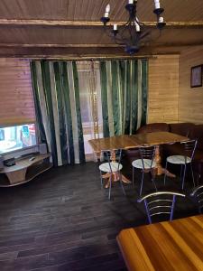 スラブスクにあるСонячні Карпатиのテーブル2台と椅子、テレビが備わる客室です。