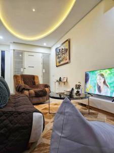 a living room with a large flat screen tv at Aksara de jivva at Pakuwon indah Cluster in Surabaya